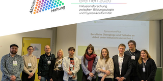 Gruppenfoto von zehn Personen, die erfreut in Richtung Kamera schauen. Im Hintergrund ist eine Powerpoint-Präsentation zum Thema "Berufliche Übergänge und Teilhabe an Arbeit unter Inklusionsverzeichen" zu sehen.